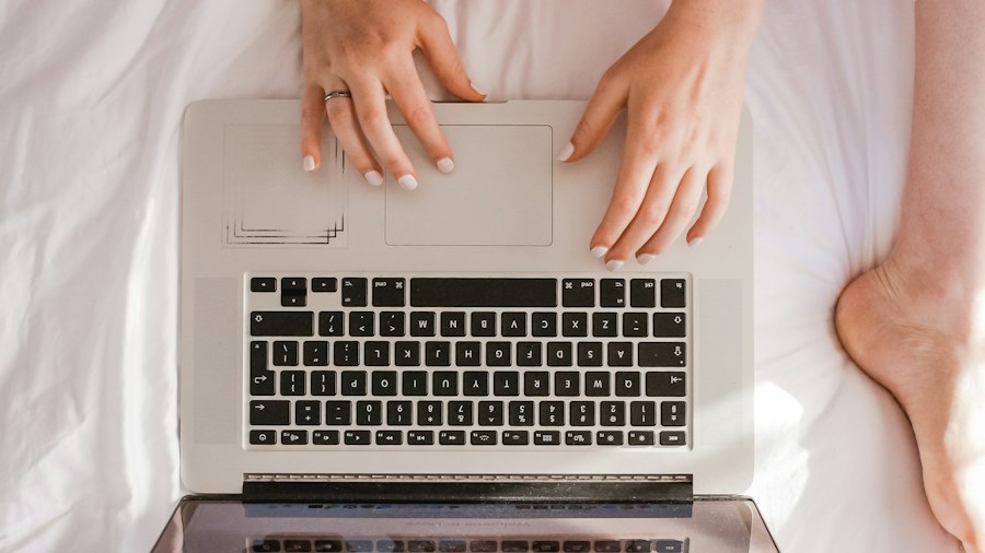 Hands using a laptop at a light-colored desk