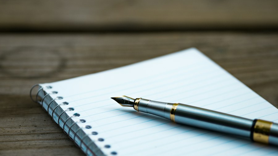 A fountain pen resting on a lined notebook